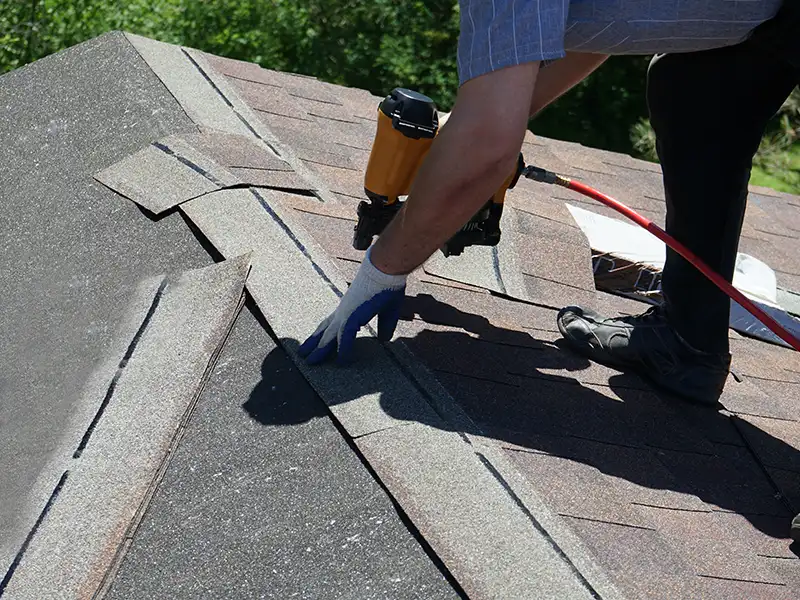 Roofer installing new shingles